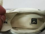 a person holding a pair of shoes with a key on it