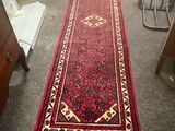 un long tapis rouge orné d'un motif en losanges au milieu