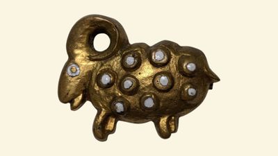 un petit mouton doré avec des taches blanches sur le museau