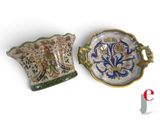 two pieces of pottery sitting next to each other on a white surface