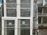 a stack of windows sitting on a pallet in a warehouse