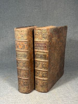 two old books sitting on top of each other on a table