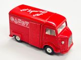 un camion jouet rouge posé sur une surface blanche
