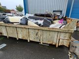 a dumpster full of junk in front of a building