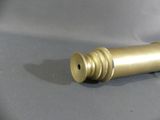 a small brass object on a gray surface