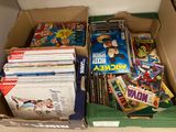 a cardboard box full of comic books on the floor