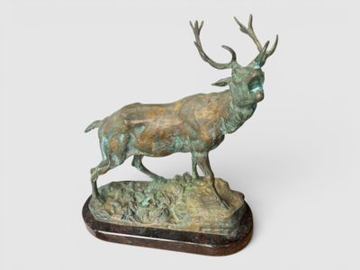 sculpture en bronze représentant un cerf, posée sur un socle en bois, sur fond blanc