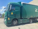 a green semi truck parked in a parking lot
