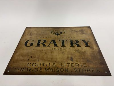 une vieille enseigne en métal sur laquelle est inscrit « Graty »