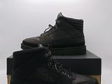 une paire de bottes noires pour homme posée sur une boîte noire