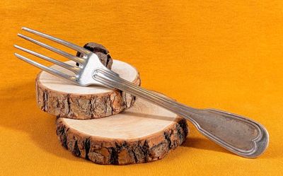 une fourchette et une cuillère posées sur un morceau de bois