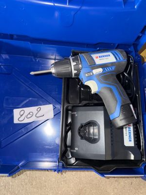 une perceuse sans fil dans une boîte bleue avec un chargeur