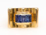 an image of a gold ring with a blue sapphire stone