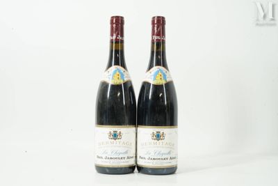 deux bouteilles de vin posées l'une à côté de l'autre sur une surface blanche