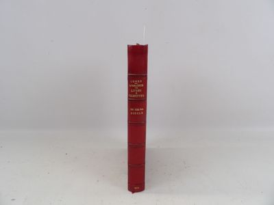 un livre rouge posé sur une table blanche