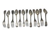 a lot of forks and spoons that are lined up together