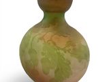 a green and yellow vase with leaves on it
