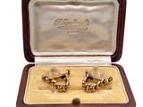 an image of a pair of gold cufflinks in a case