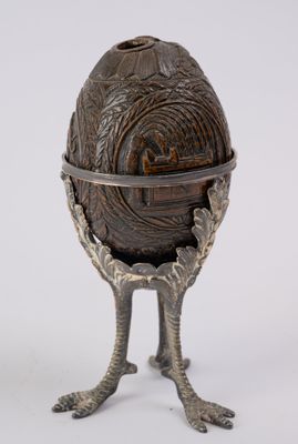 a metal egg holder that has a bird ' s feet on it