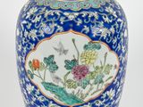 une image représentant un vase bleu et blanc orné d'un oiseau et de fleurs