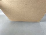 a brown paper bag with a handle on a table