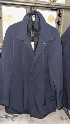 two jackets hanging on a rack in a room
