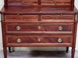 a dresser with a mirror on top of it in front of a brick wall