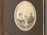 an old picture of a family in a frame hanging on a wall