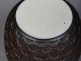 a brown vase with a white top sitting on a table