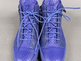 purple high top sneakers with blue laces on a white surface
