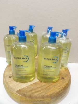 quatre flacons de savon pour les mains Bioderma posés sur un plateau en bois