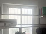 a room with a window, a desk, a chair, and a shelf