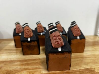 five figurines of men in suits and hats on a wooden table