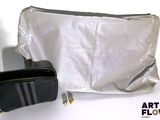 un sac argenté et un sac noir posés sur une table blanche