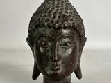 statue représentant une tête de Bouddha sur fond blanc
