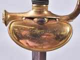 a close up of a gold colored sword with a black handle