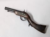 an old gun with a wooden handle on a white surface