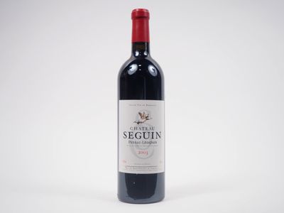 une bouteille de vin rouge posée sur une table blanche