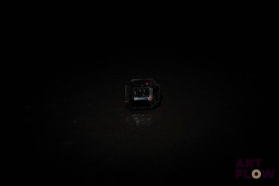 un petit objet carré au milieu d'une pièce sombre