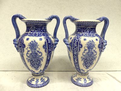 pair of blue and white vases sitting on top of a white table