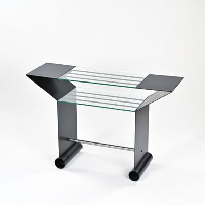 une photo d'une table en verre avec des pieds noirs et un plateau en verre