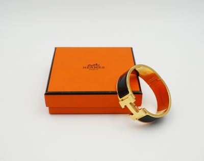 une boîte orange contenant un bracelet noir et doré