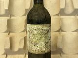une bouteille de vin posée sur une table devant un clavier