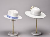 two white hats are sitting on top of a table next to each other