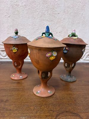 trois petits pots posés sur une table en bois