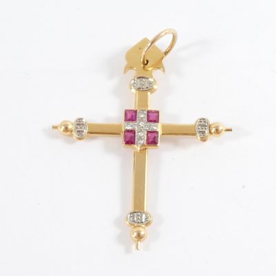 a close up of a gold cross with pink stones on a white background