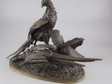 une image représentant une statue en bronze d'un oiseau perché sur une branche