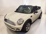 une photo d'une Mini Cooper décapotable blanche garée dans une pièce blanche
