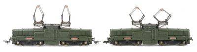 two green trains sitting side by side on a white surface