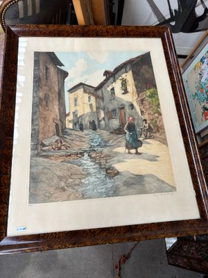 photo encadrée représentant une femme marchant dans une rue d'un village